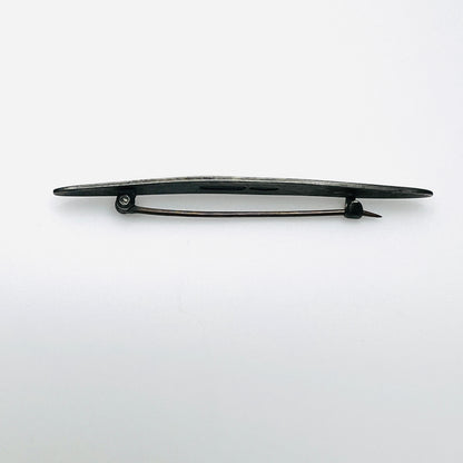 Side view of antique sterling silver enamel brooch showing C-clasp pin