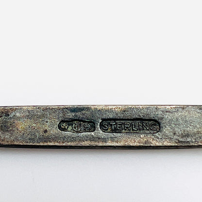Antique brooch hallmark detail showing pictorial marks and STERLING stamp