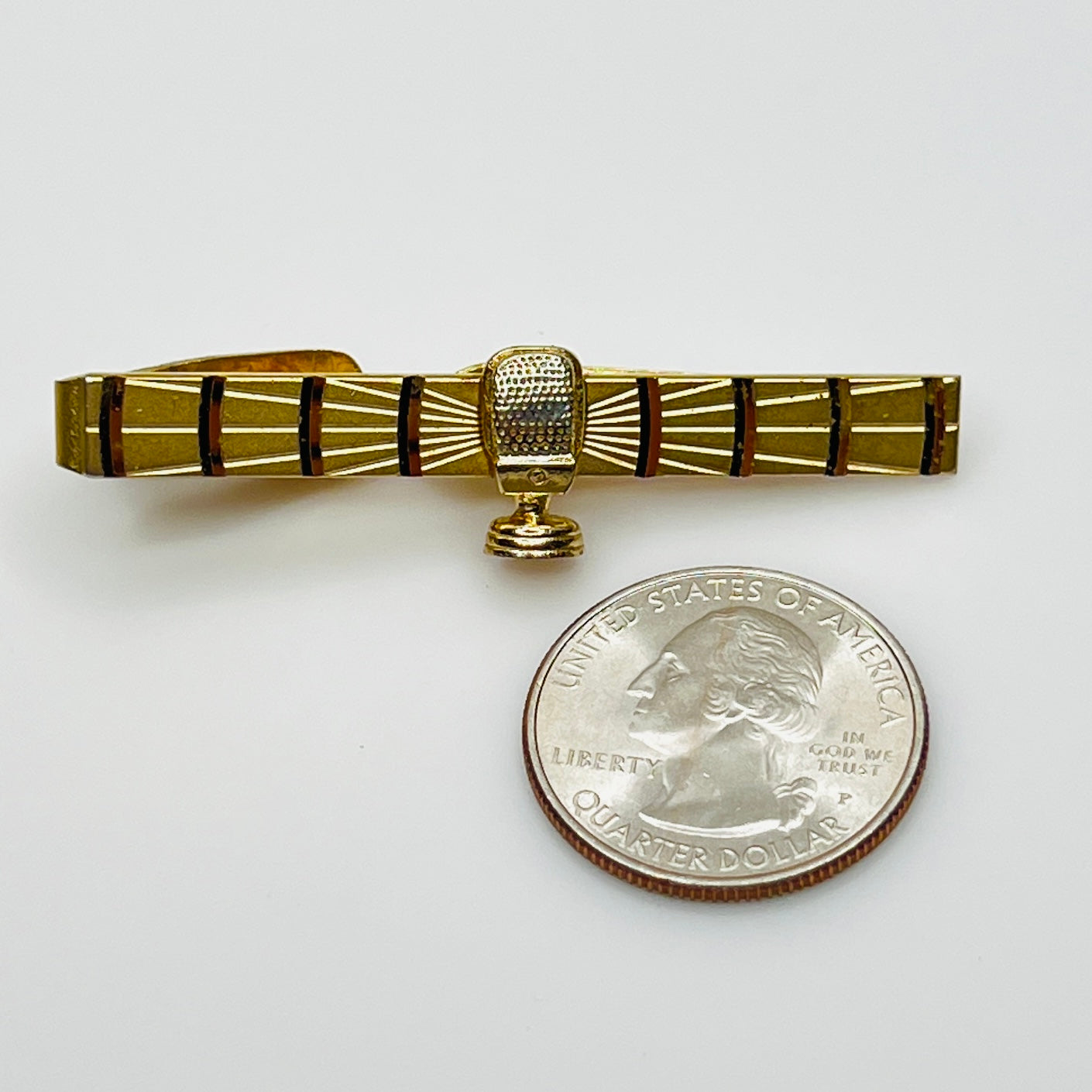 Retro Swank microphone tie bar shown next to quarter for scale