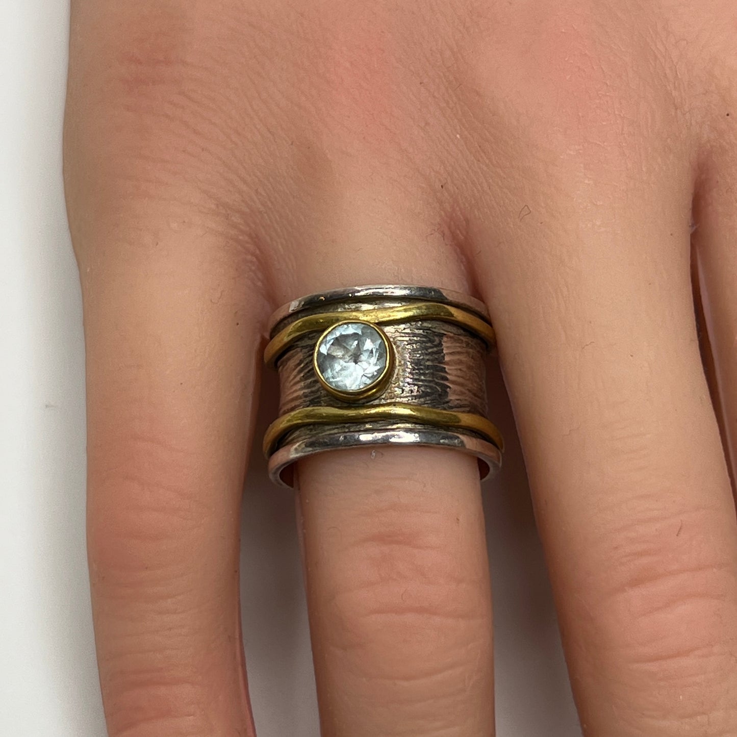 Wide sterling silver and brass spinner ring with blue sapphire stone, size 7