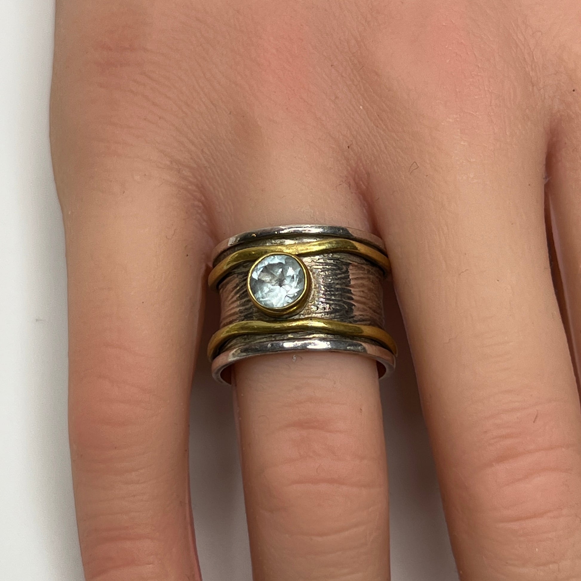 Wide sterling silver and brass spinner ring with blue sapphire stone, size 7