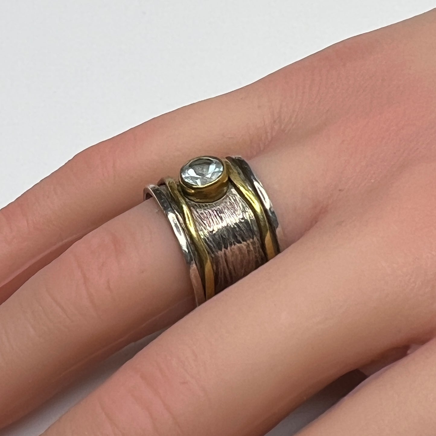 Wide sterling silver and brass spinner ring with blue sapphire stone, size 7