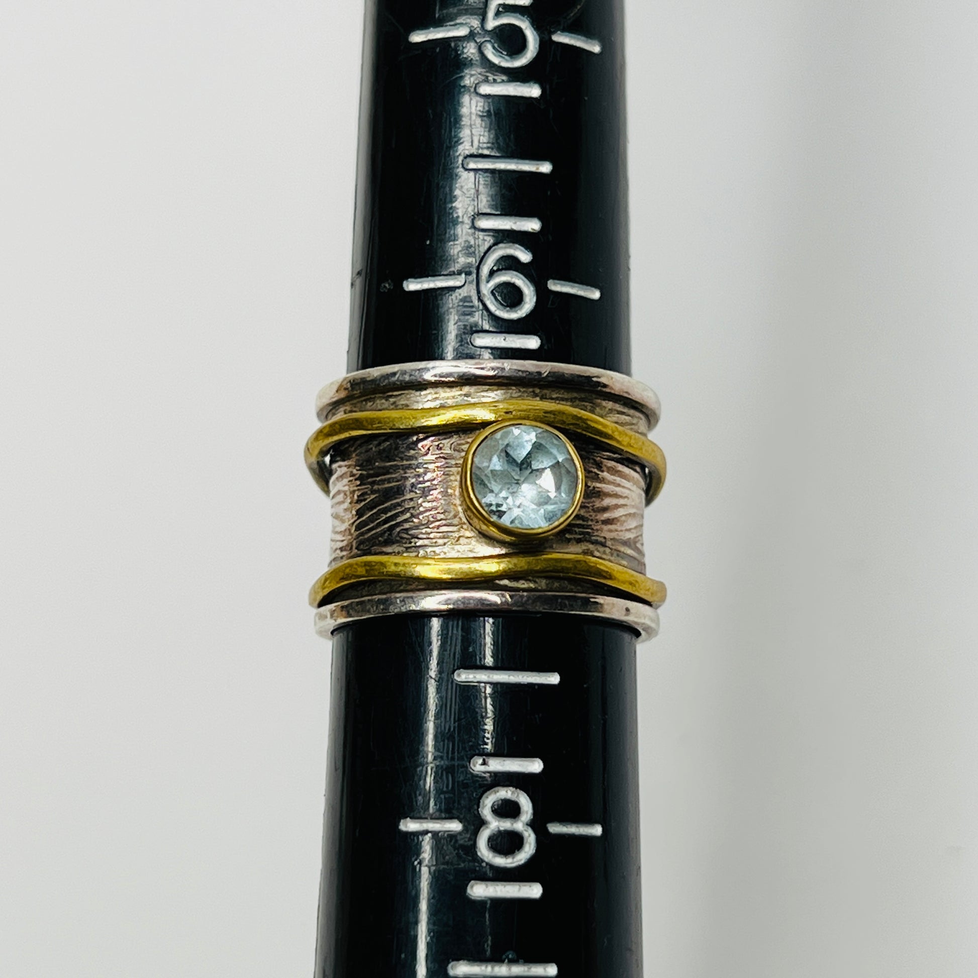 Close-up of vintage fidget worry ring with sapphire and mixed metals