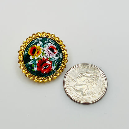 Close-up of round micro mosaic pin with red, pink, and yellow flowers