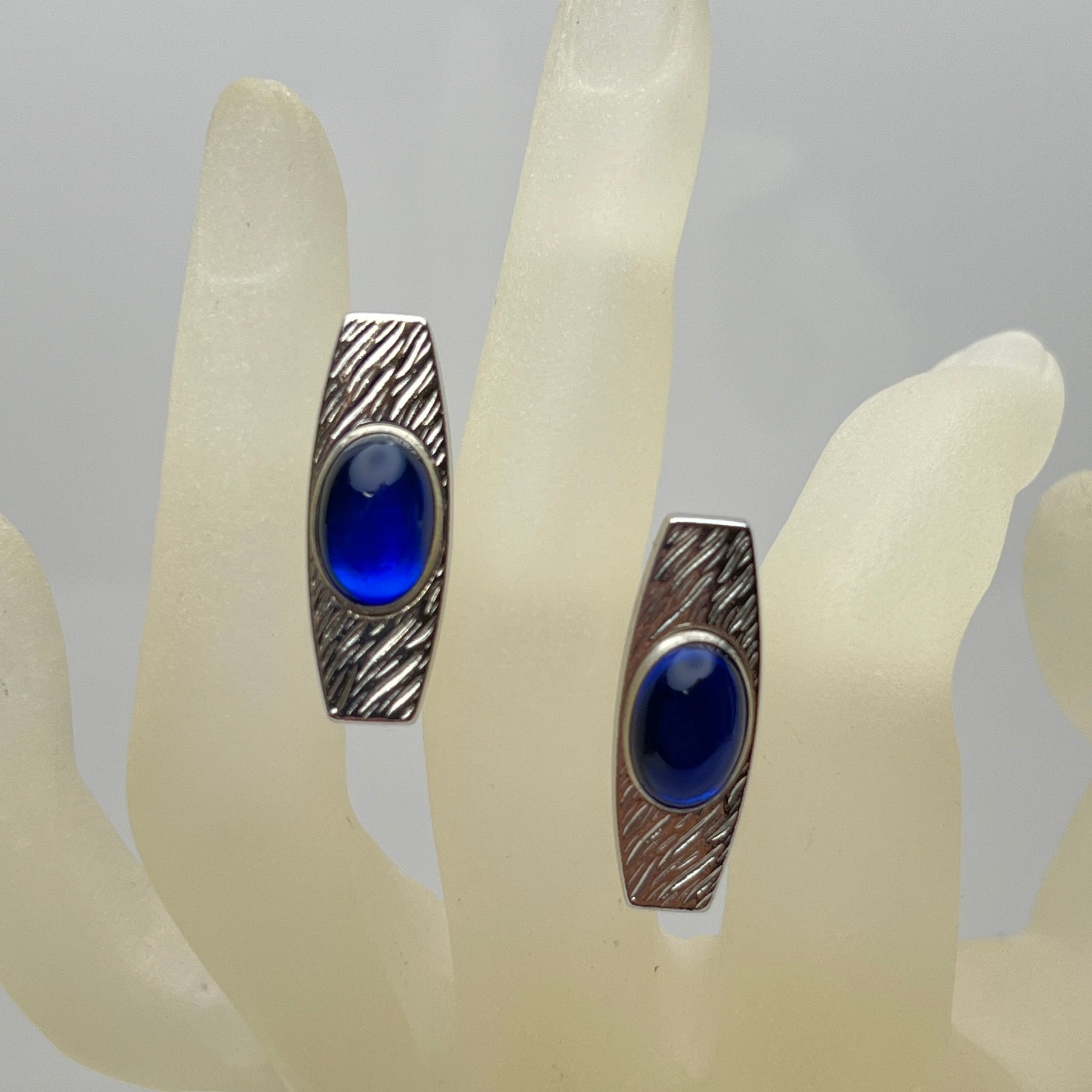 Silver-tone cufflinks with textured finish and vivid blue lucite cabochons, signed Anson