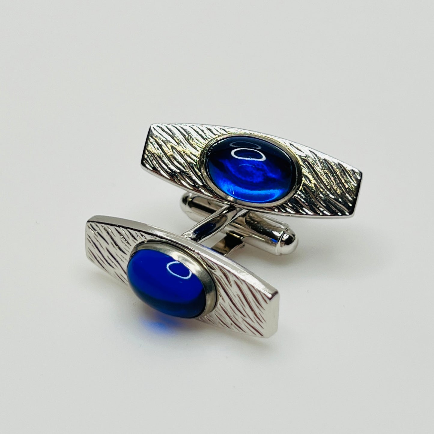 Silver-tone cufflinks with textured finish and vivid blue lucite cabochons, signed Anson
