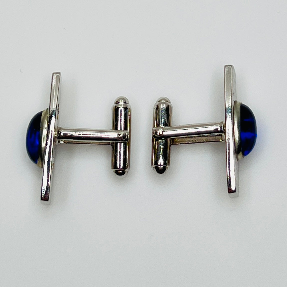 Silver-tone cufflinks with textured finish and vivid blue lucite cabochons, signed Anson