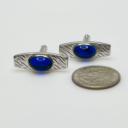 Silver-tone cufflinks with textured finish and vivid blue lucite cabochons, signed Anson