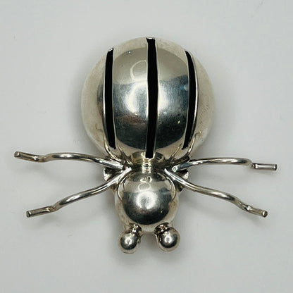 Sterling silver spider brooch with stylized body and curved legs