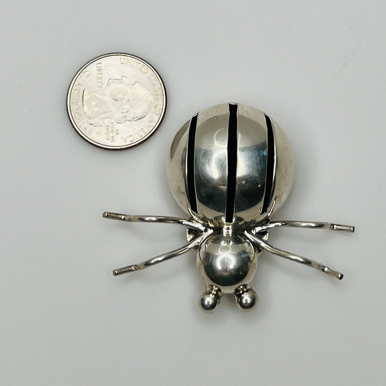 Spider brooch shown with a U.S. quarter for scale