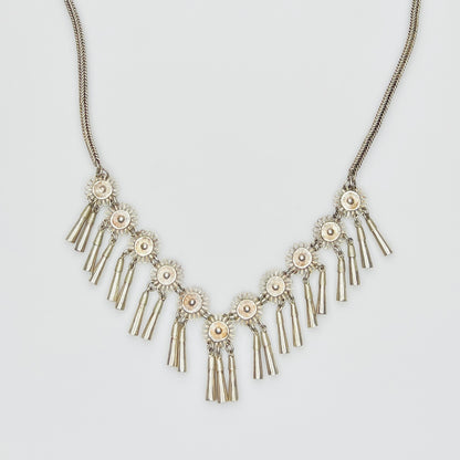 Close-up of silver floral medallions with cone tassels