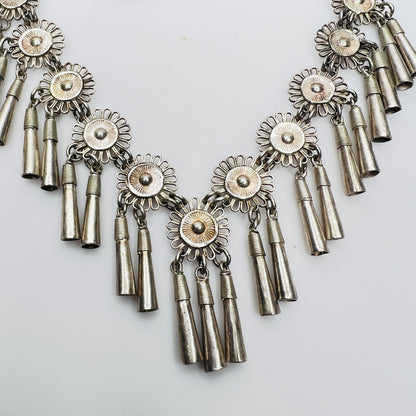 Close-up of silver floral medallions with cone tassels