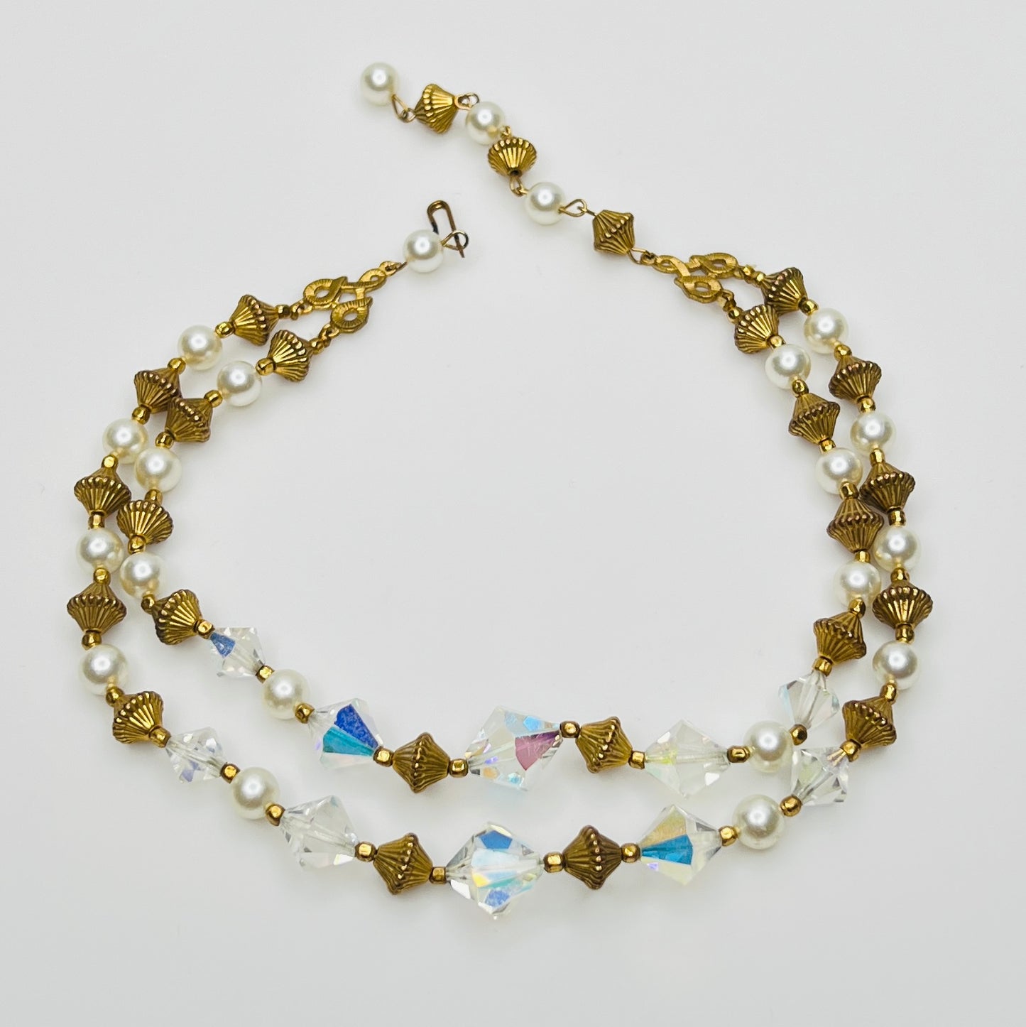 Double-strand necklace with faux pearls, iridescent crystals, and brass beads laid flat