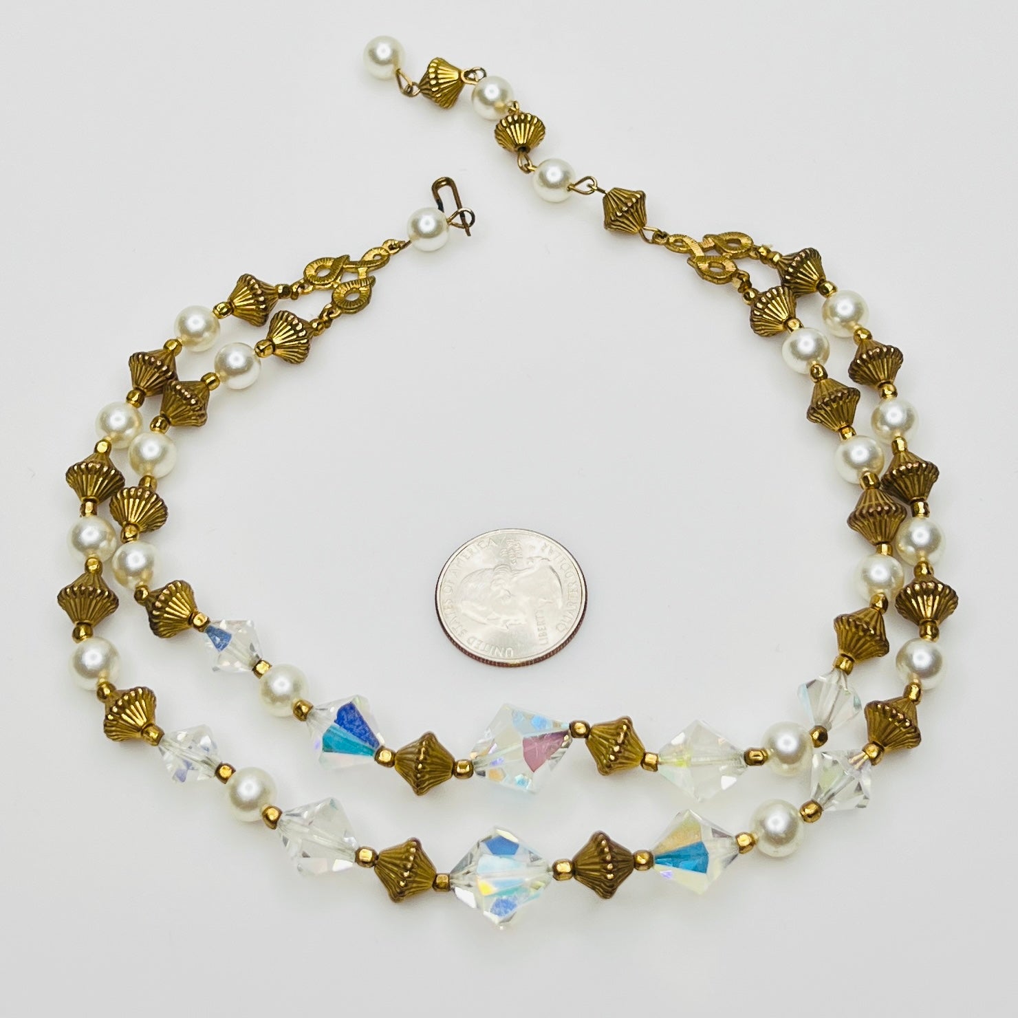 Double-strand necklace with faux pearls, iridescent crystals, and brass beads laid flat