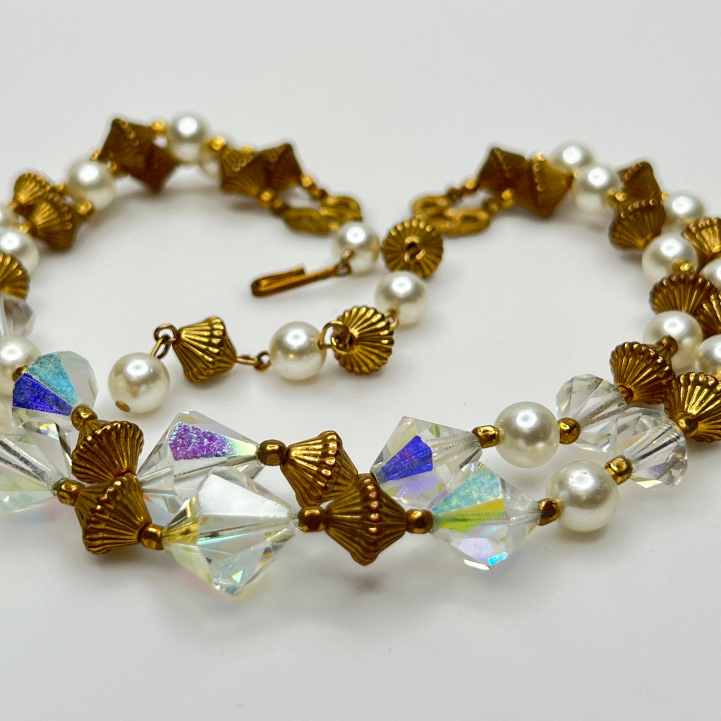 Double-strand necklace with faux pearls, iridescent crystals, and brass beads laid flat
