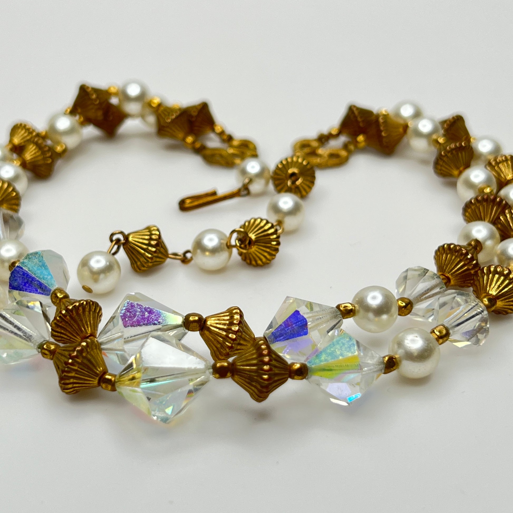 Double-strand necklace with faux pearls, iridescent crystals, and brass beads laid flat