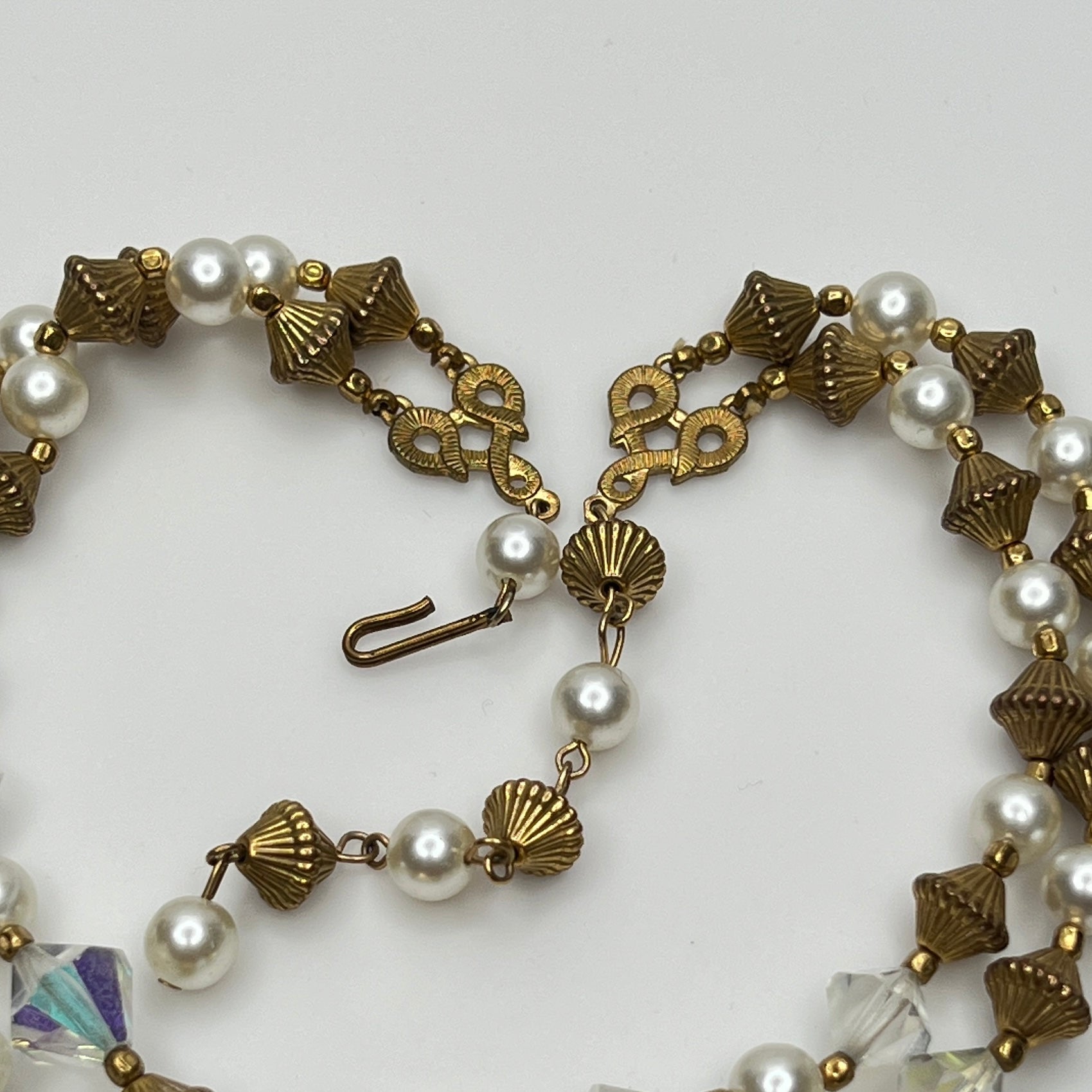 Double-strand necklace with faux pearls, iridescent crystals, and brass beads laid flat