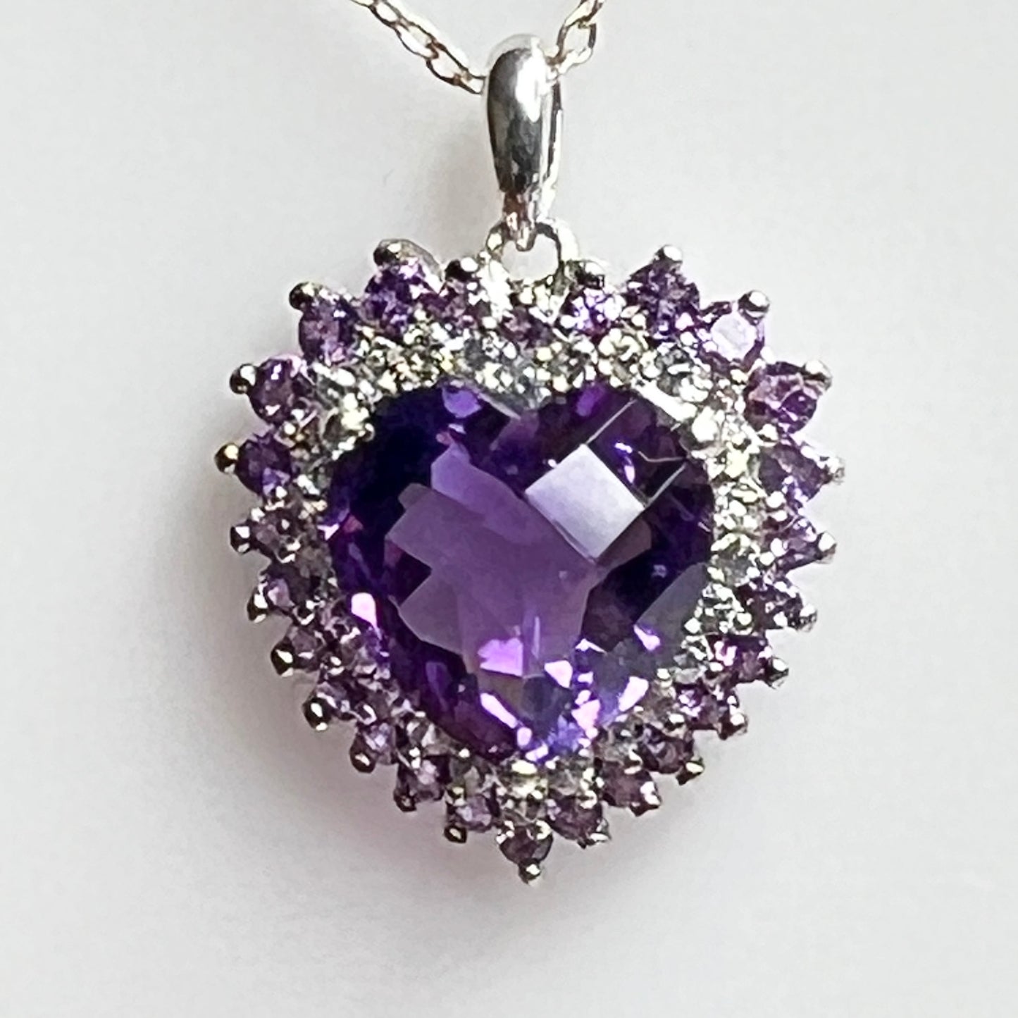 Close up cushion cut amethyst heart with diamond halo