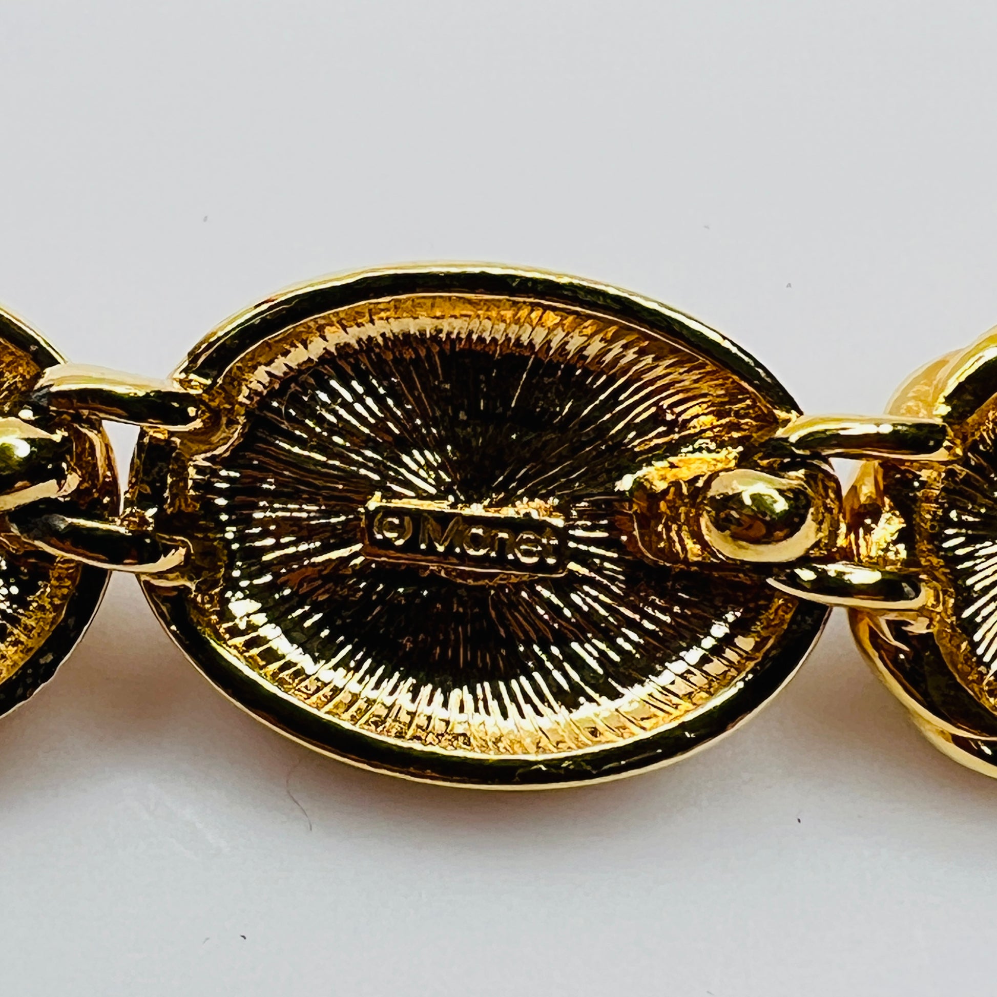 Close-up of Monet signature on back of goldtone necklace link