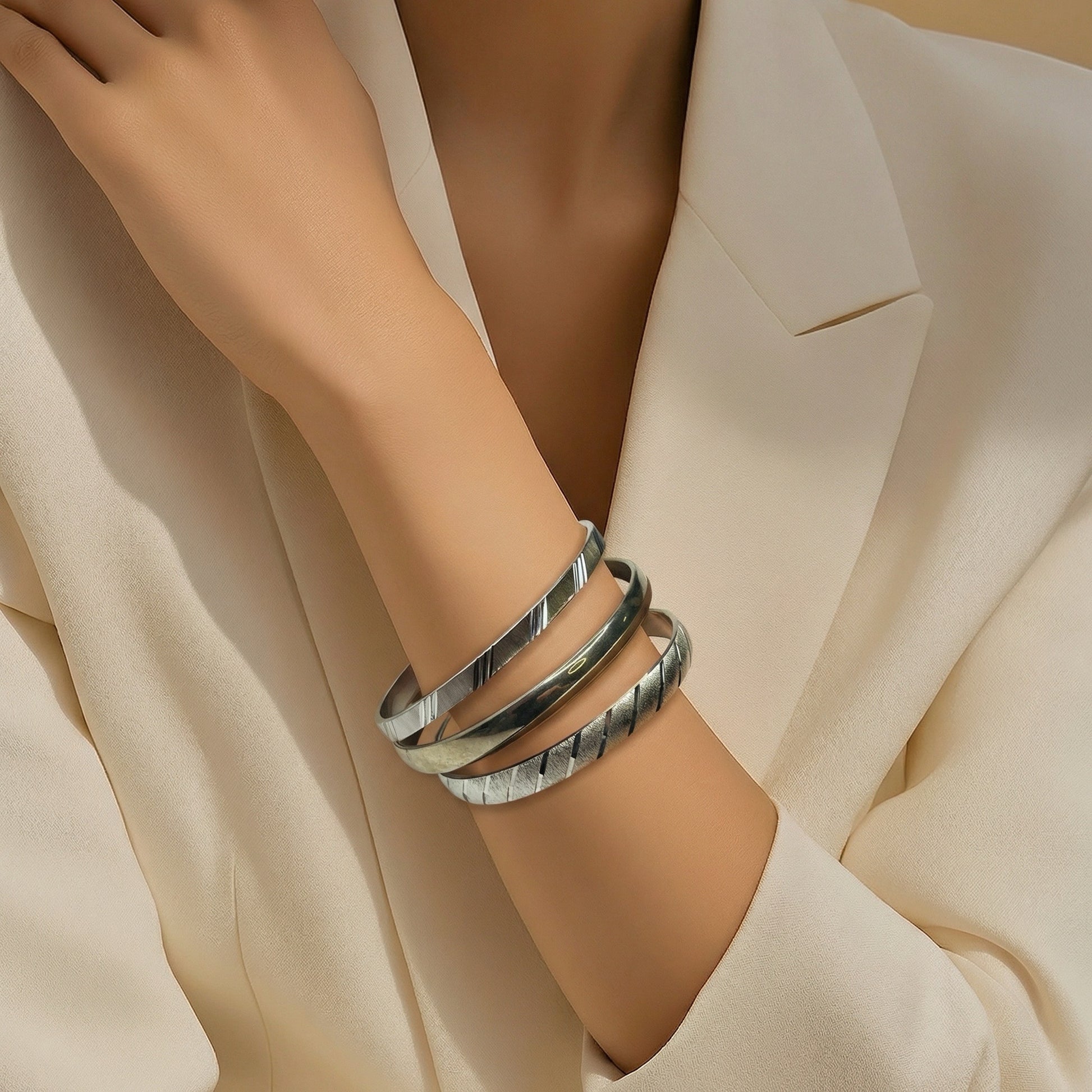 1980s Monet silver bangles stacked on wrist