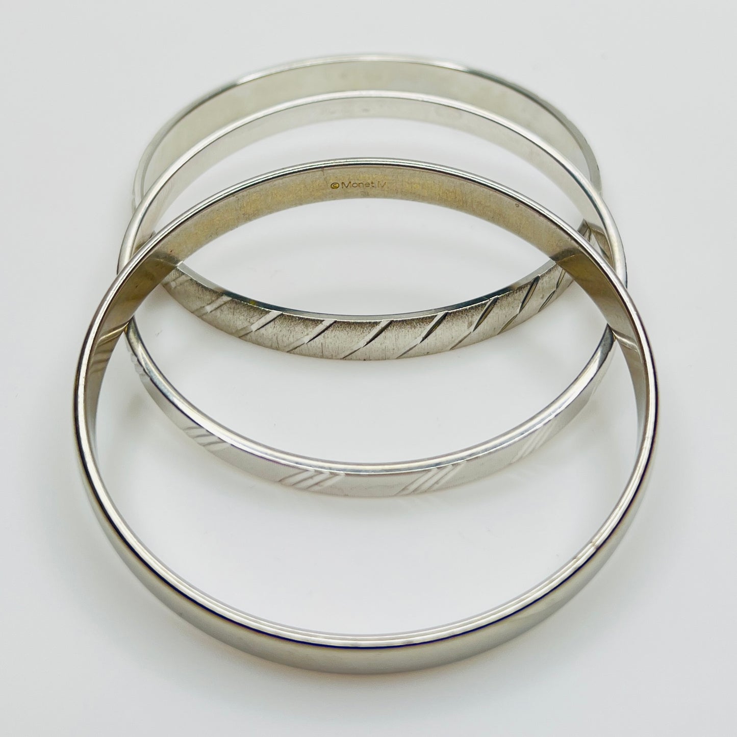 Signed Monet silver tone bangle trio, smooth and textured