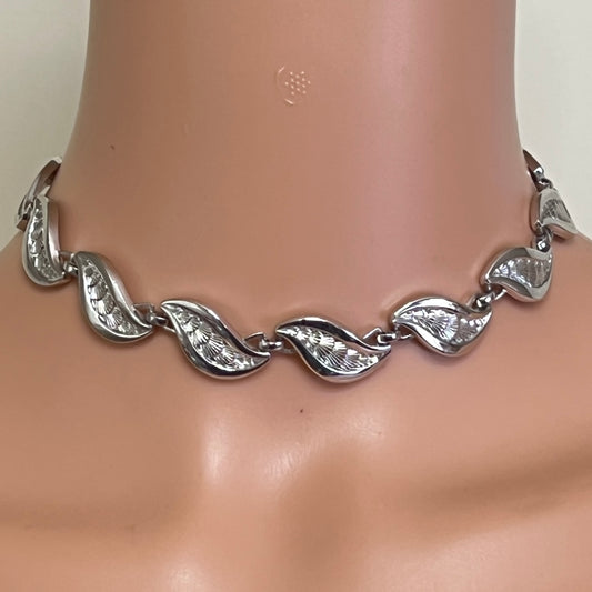 Close-up of silver Monet choker with curved leaf links on mannequin neck