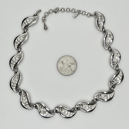 Overhead view of full silver Monet necklace with etched leaf design and extender chain