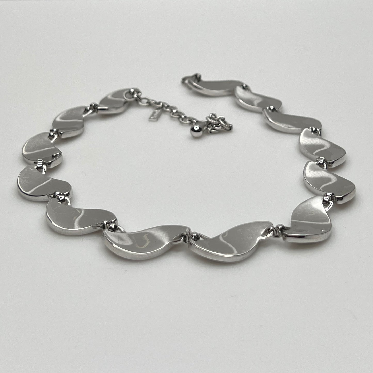 side view Close-up of silver Monet choker with curved leaf links