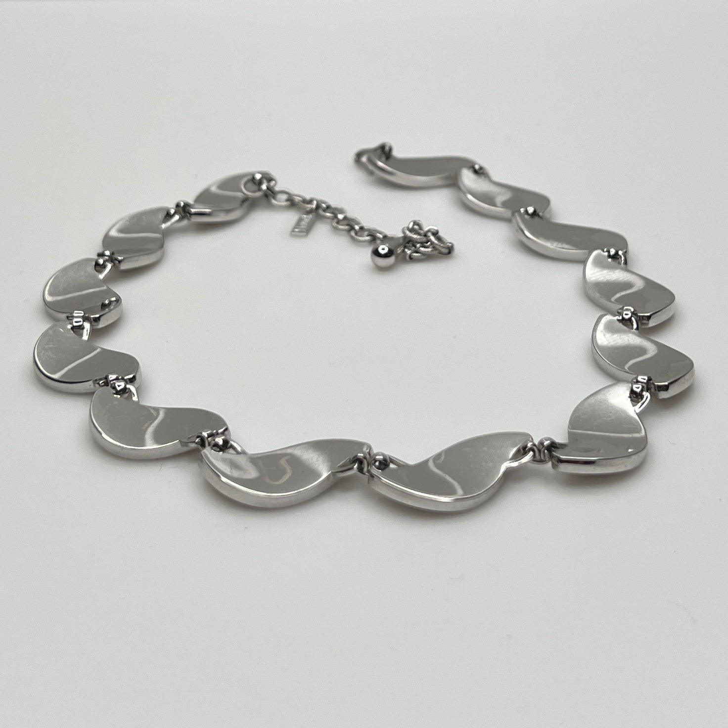 side view Close-up of silver Monet choker with curved leaf links