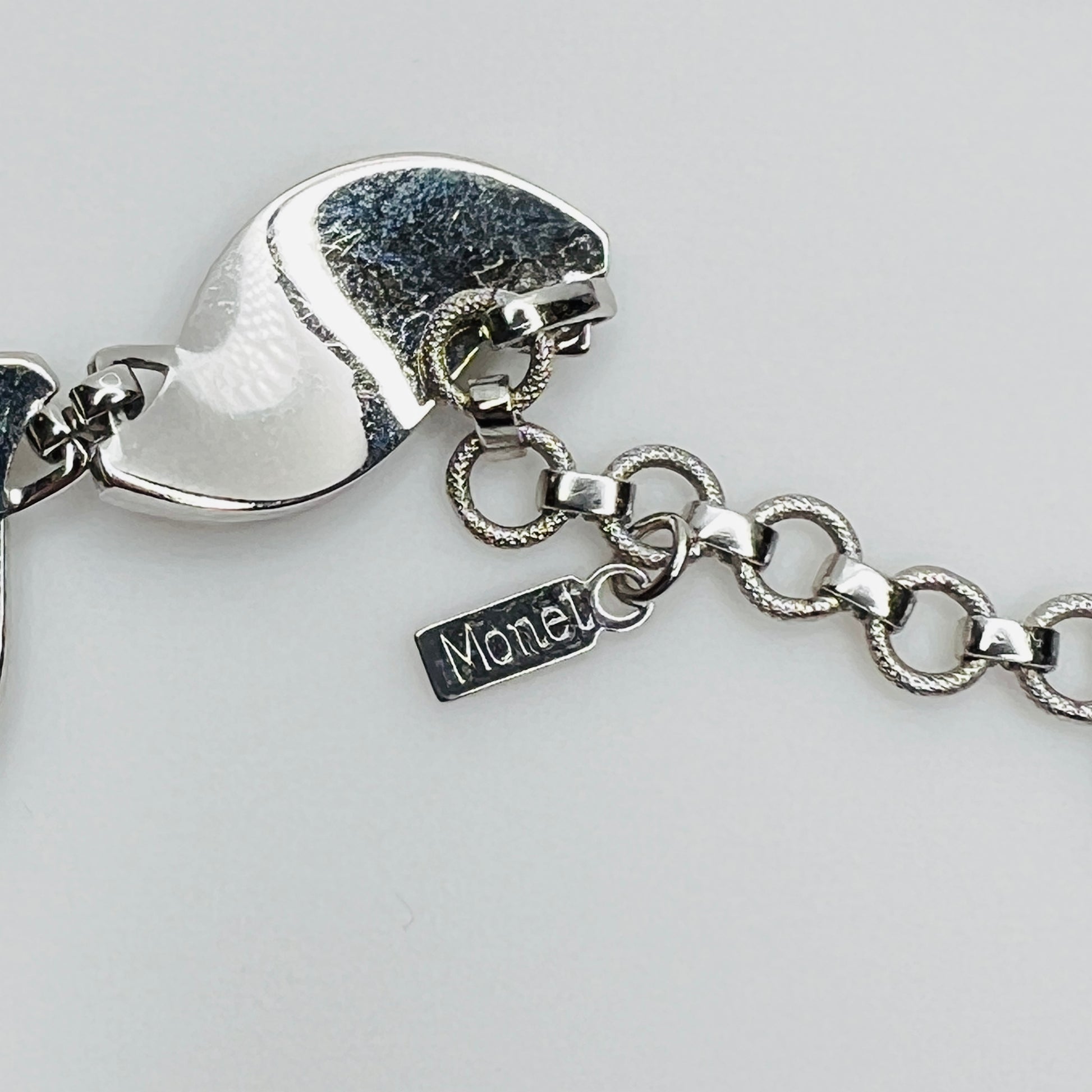 Close-up of silver Monet choker hang tag with curved leaf links