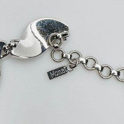 Close-up of silver Monet choker hang tag with curved leaf links