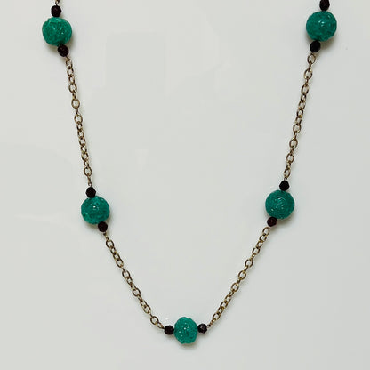 Long vintage necklace with green threaded glass beads and red spacers on gold-tone chain