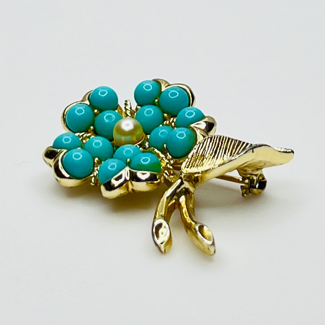 1960s floral brooch with faux turquoise cabochons and pearl center