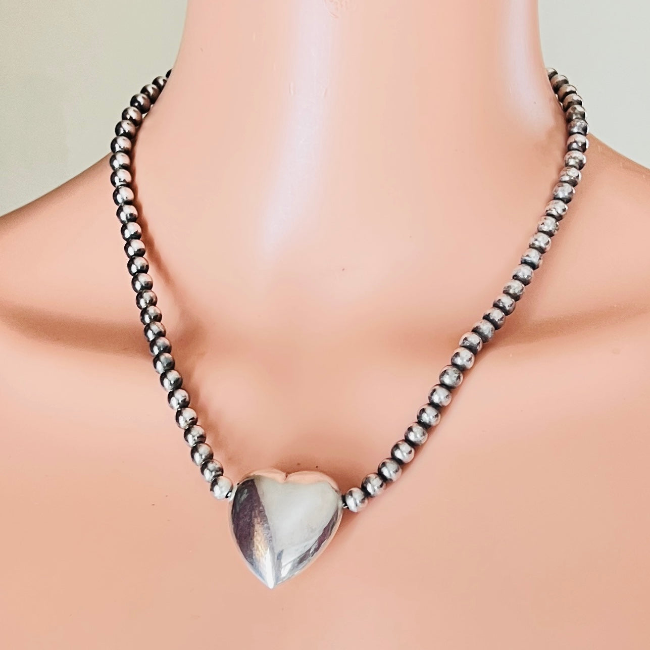 Sterling puff heart necklace with beaded strand on mannequin