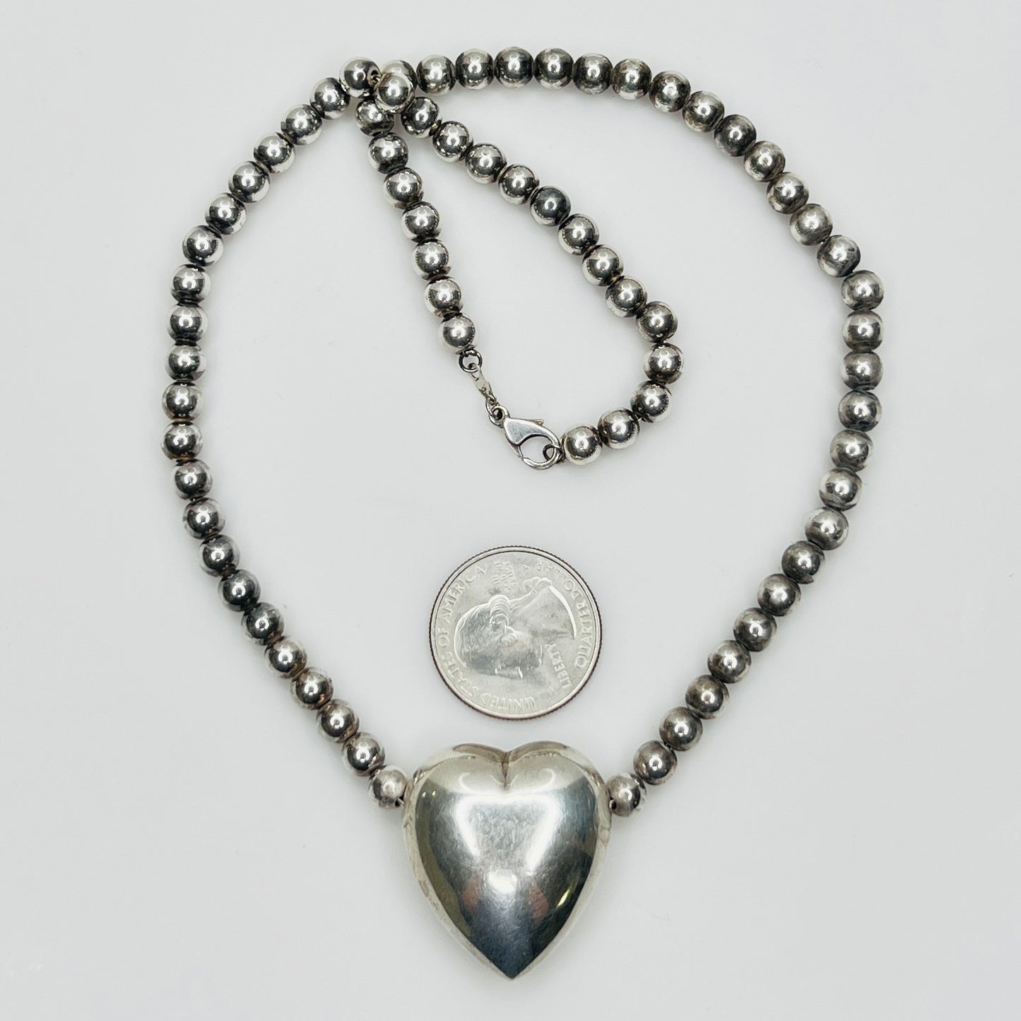 Flat lay of vintage sterling heart necklace with lobster clasp