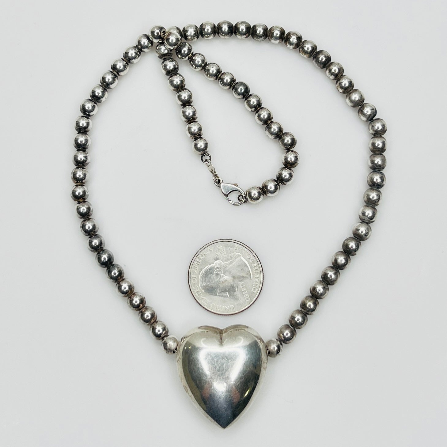 Flat lay of vintage sterling heart necklace with lobster clasp