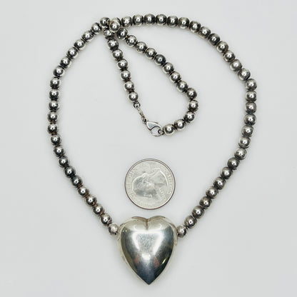 Flat lay of vintage sterling heart necklace with lobster clasp