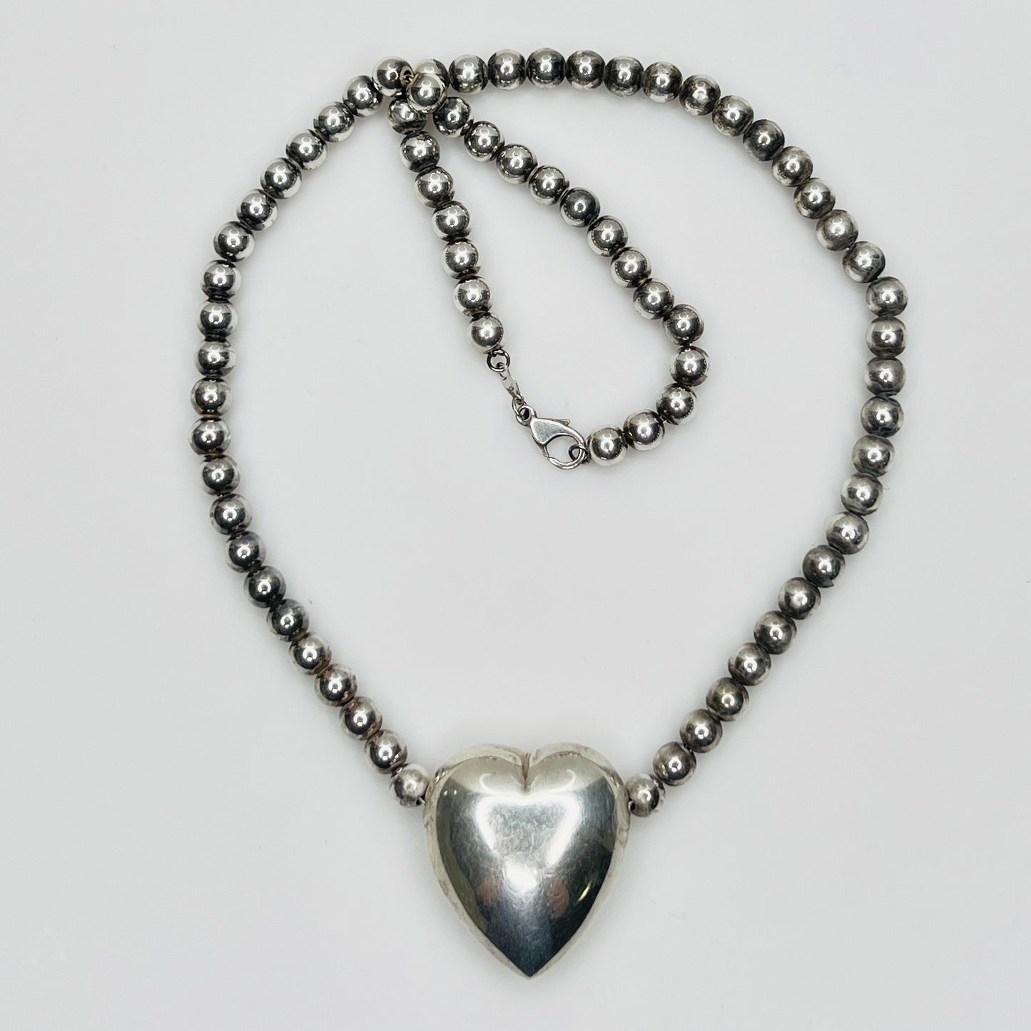 Flat lay of vintage sterling heart necklace with lobster clasp