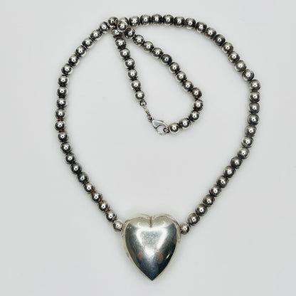Flat lay of vintage sterling heart necklace with lobster clasp