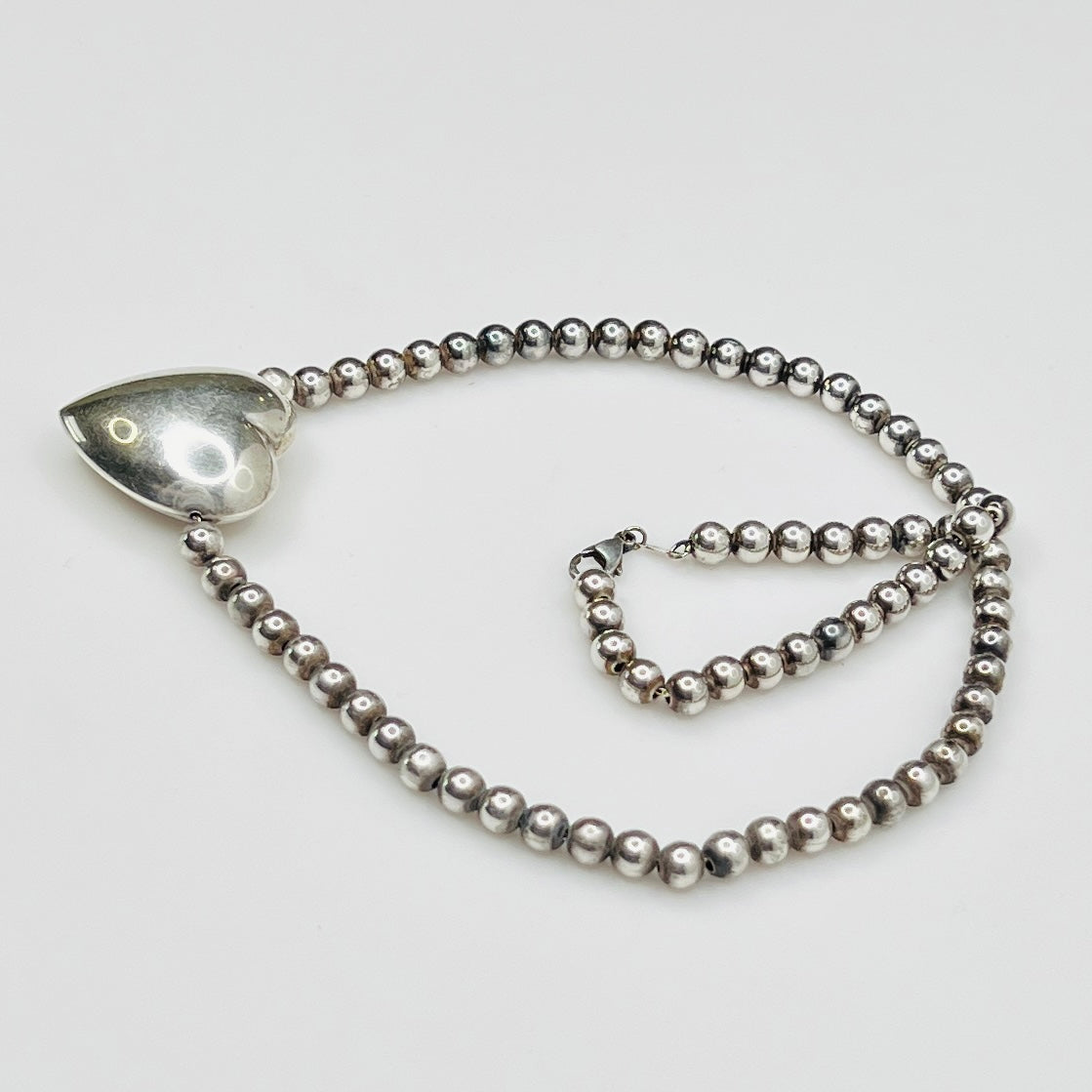 Side view Flat lay of vintage sterling heart necklace with lobster clasp