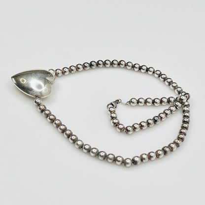 Side view Flat lay of vintage sterling heart necklace with lobster clasp
