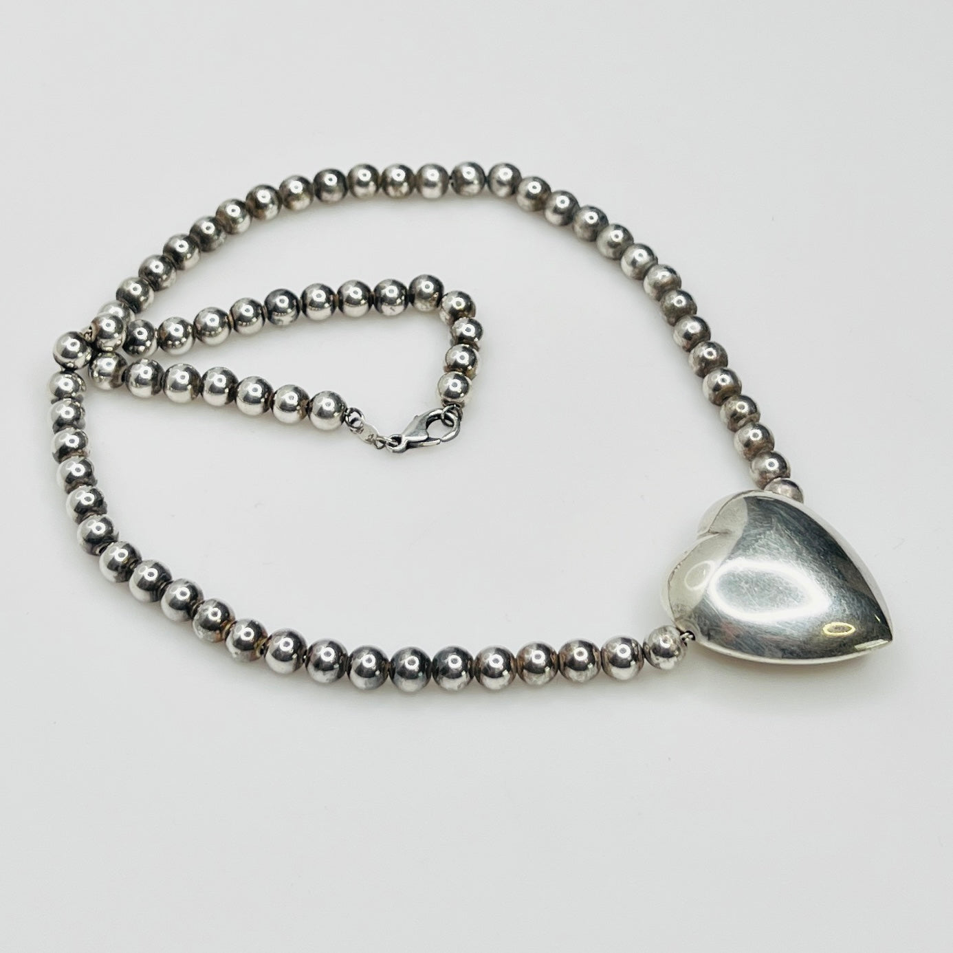 Side view Flat lay of vintage sterling heart necklace with lobster clasp