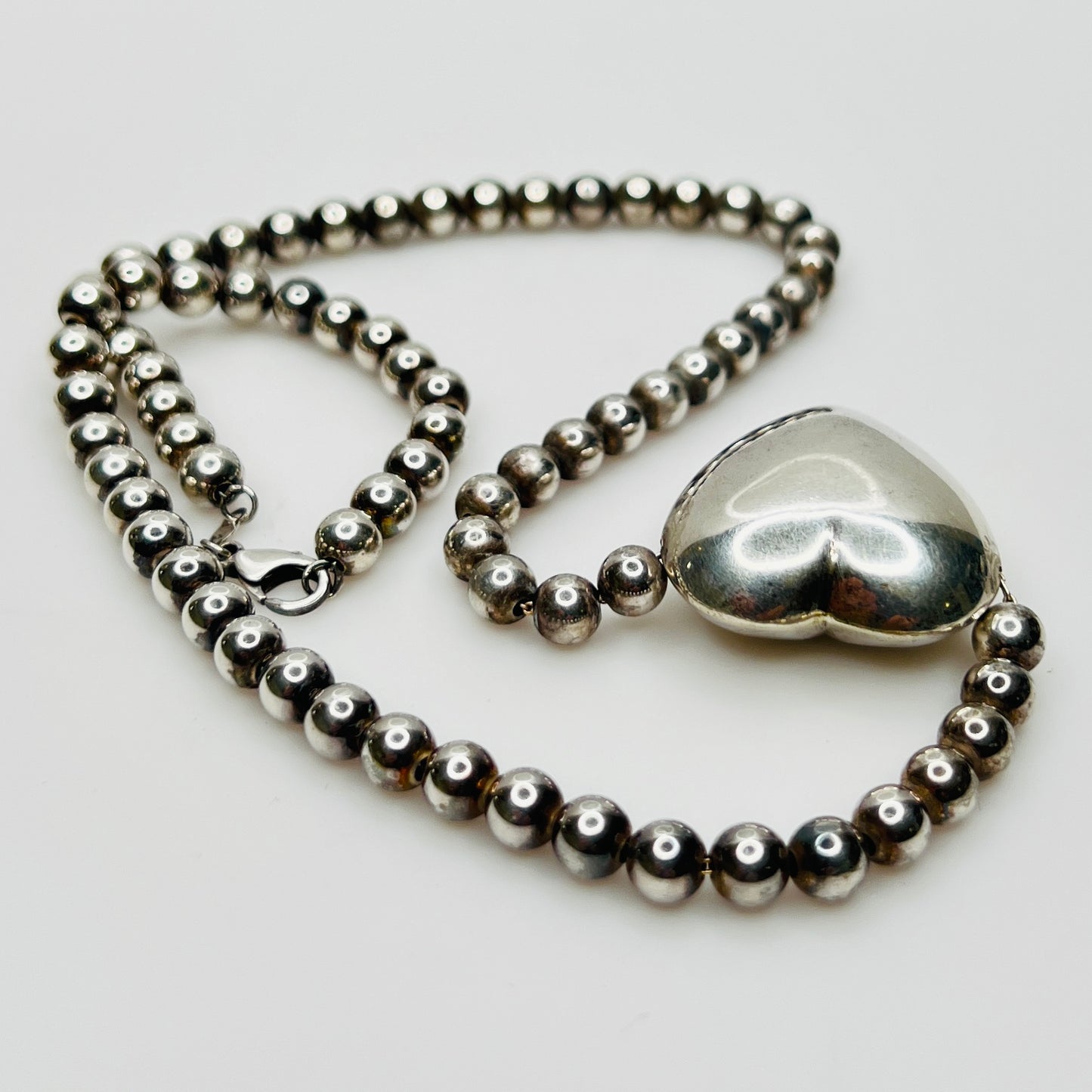 Side view Flat lay of vintage sterling heart necklace with lobster clasp