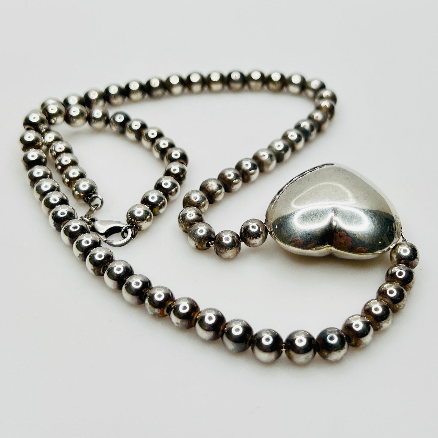 Side view Flat lay of vintage sterling heart necklace with lobster clasp