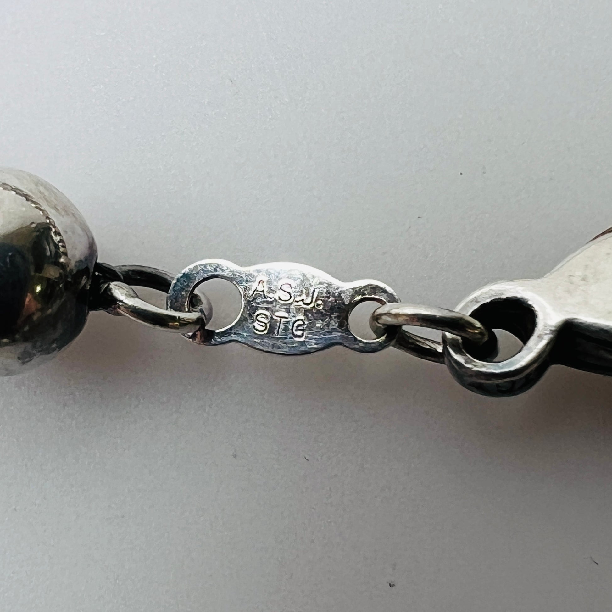 Clasp close-up stamped "ASJ STG" on sterling connector