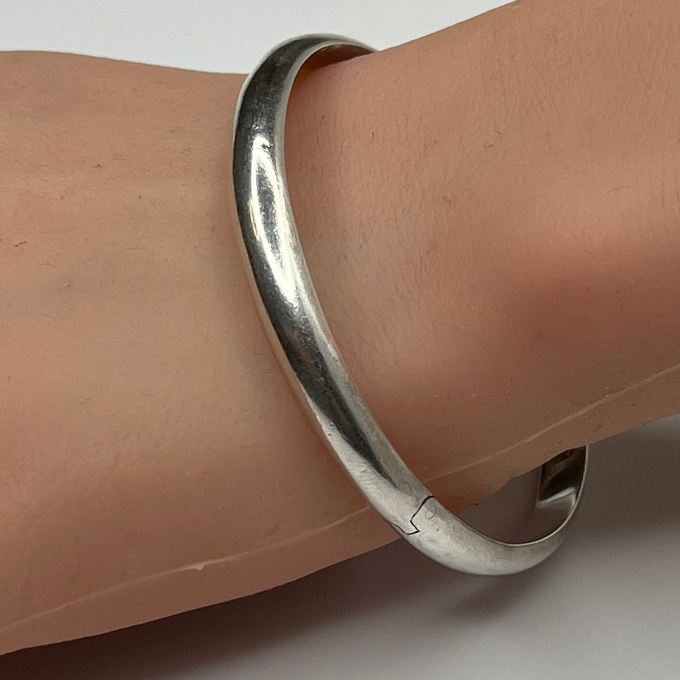 Sterling silver vintage bangle bracelet on wrist – smooth polished finish