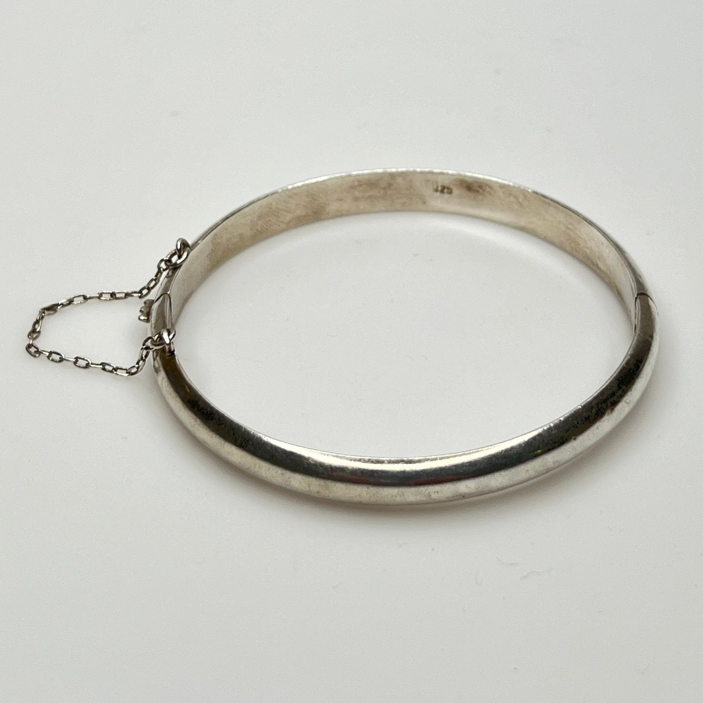 Full view of 1980s bangle with safety chain, laying flat