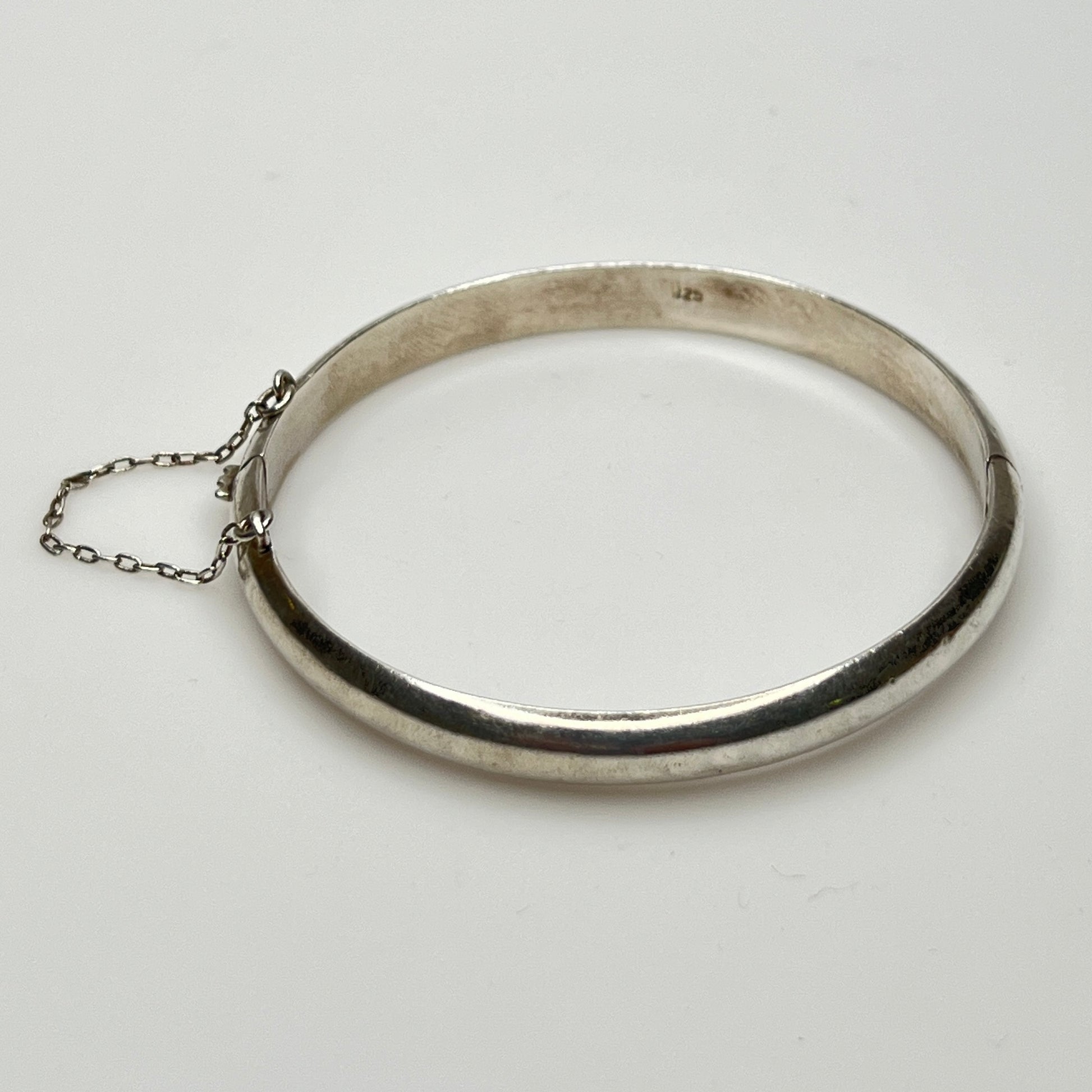 Full view of 1980s bangle with safety chain, laying flat