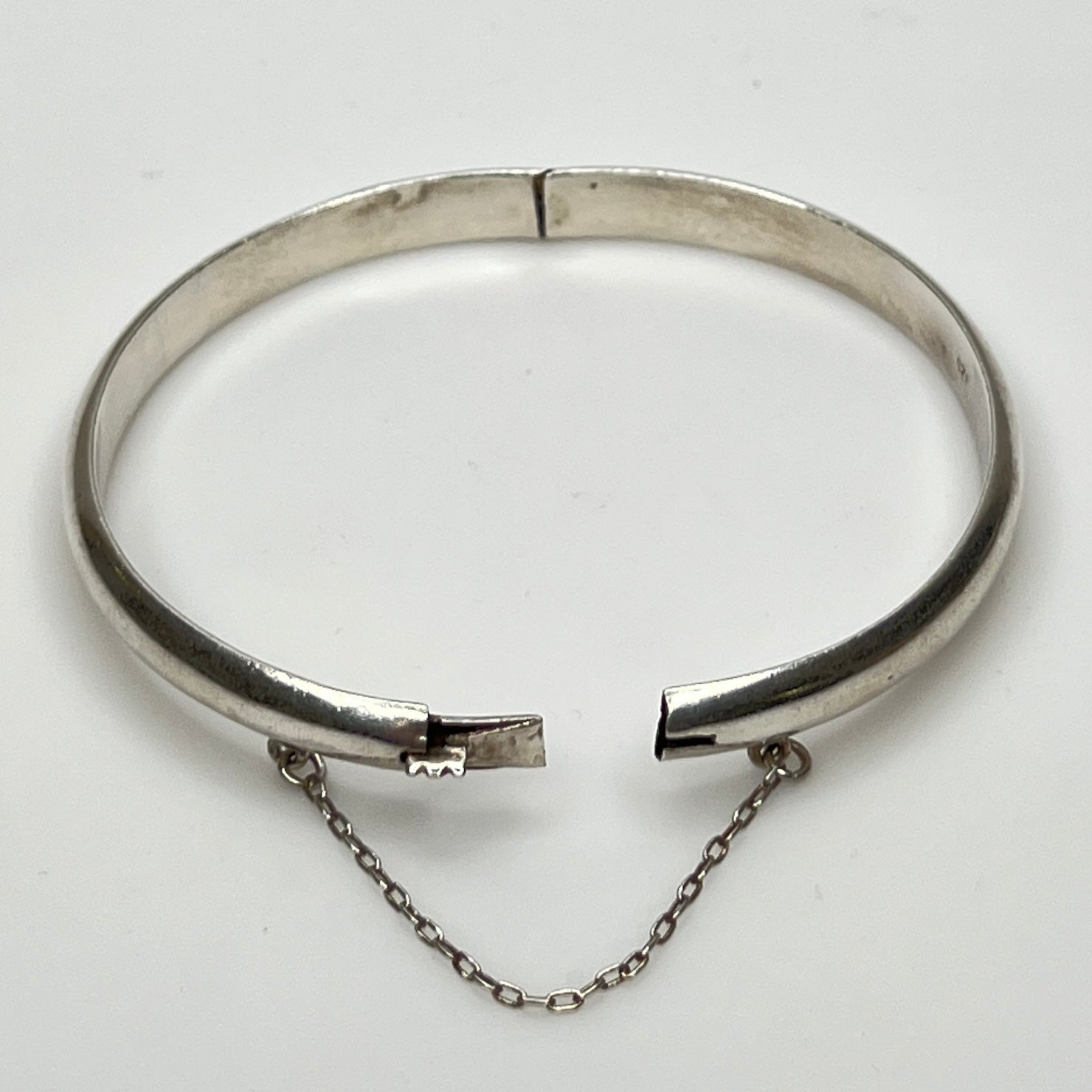 Full view of 1980s bangle with safety chain, laying flat