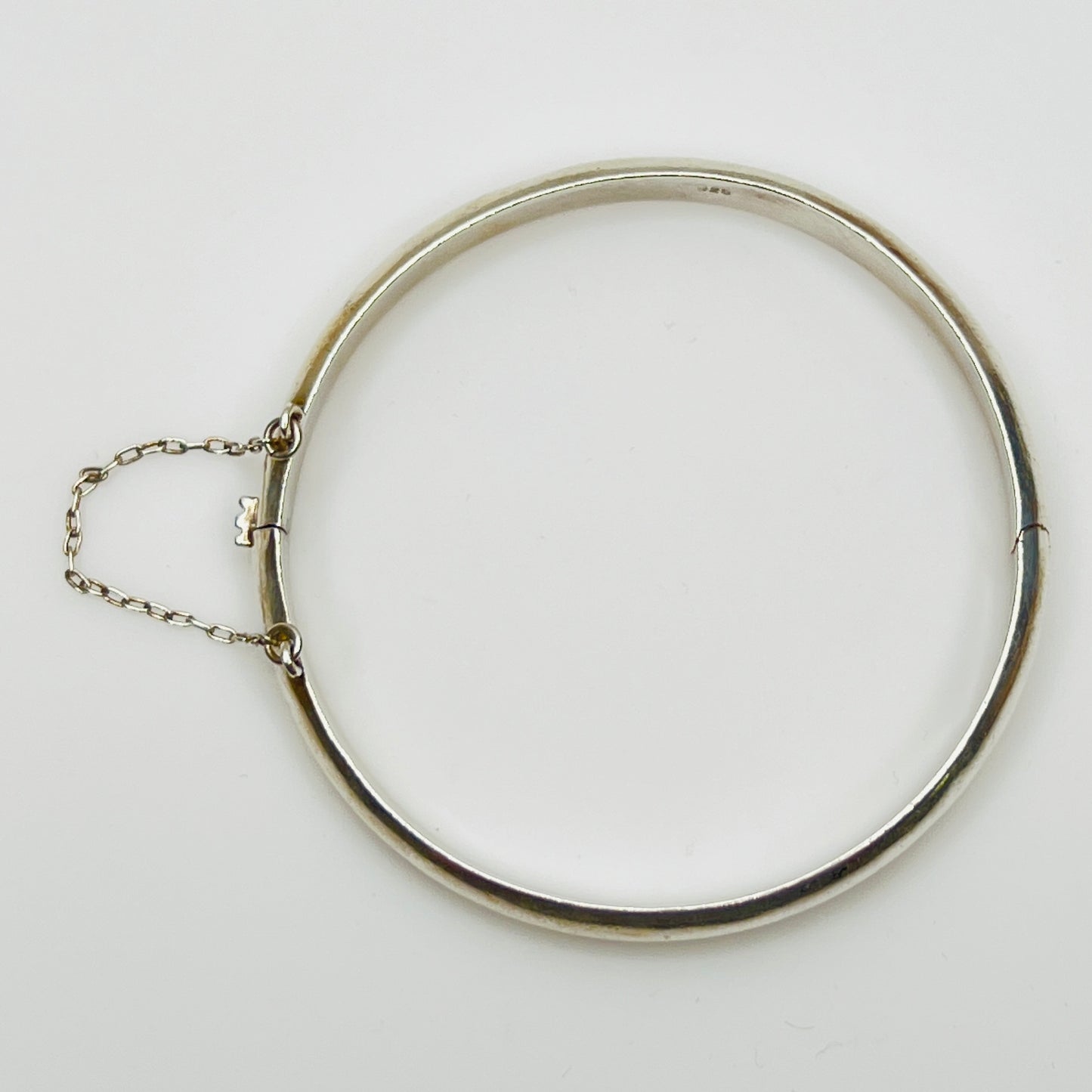 Full view of 1980s bangle with safety chain, laying flat